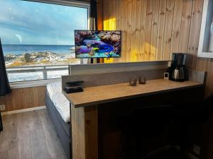 a room with a desk with a view of the ocean at Unik og moderne microhytte med utsikt mot havet 40 A Otterlei Resort in Longva