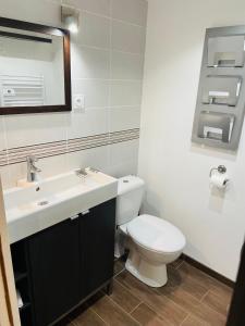 a bathroom with a white toilet and a sink at Dépendance chez l'habitant in Morlaix