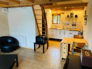 a kitchen with a loft bed and a kitchen with a table at Dépendance chez l'habitant in Morlaix +1 photo