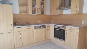 a kitchen with wooden cabinets and a sink at Gästehaus Cavallo in Achberg