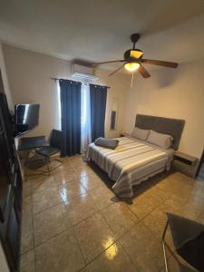 a bedroom with a bed and a ceiling fan at Habitacion Cedro in Saltillo +6 photos