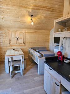 a kitchen with a bed and a table in a cabin at Camping La Ribera Salada in Ogern