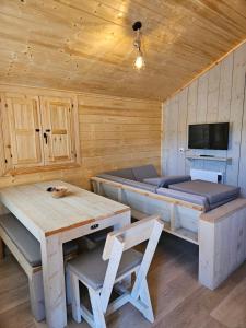 a log cabin with a bed and a table and chairs at Camping La Ribera Salada in Ogern
