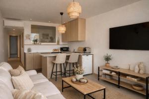 a living room with a white couch and a kitchen at Solange by Port Azur Rental in Cogolin