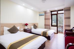 a hotel room with two beds and a window at Sao Mai Bac Ha Hotel in Bắc Hà +14 photos