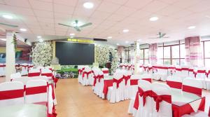 a room with red and white chairs and a screen at Sao Mai Bac Ha Hotel in Bắc Hà