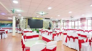 a conference room with white chairs and a screen at Sao Mai Bac Ha Hotel in Bắc Hà