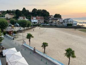 a view of a beach with palm trees and buildings at Casa Grila in Pontevedra