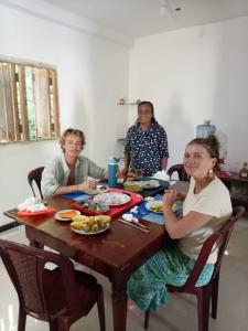 a group of people sitting at a table eating food at White shell in Sinimodera