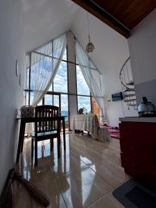 a room with a table and a chair in a room at Pijar Jingga Cabin in Diyeng