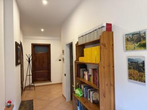 a hallway with a book shelf with books at La Casa Gialla in Lucca