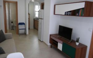 sala de estar con TV de pantalla plana sobre una mesa en Apartamento Los Flamencos, en Cabo de Gata