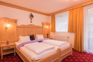 a bedroom with a large bed with orange curtains at Hotel Mölltalerhof in Rangersdorf