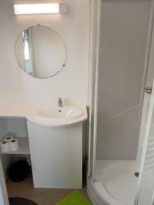 a white bathroom with a sink and a mirror at Bungalow & Jacuzzi 24h24 7j7 in Petite Île