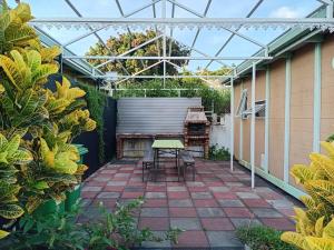 a patio with a table and chairs in a greenhouse at Bungalow & Jacuzzi 24h24 7j7 in Petite Île