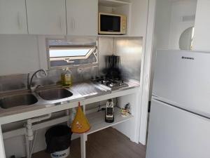 a small kitchen with a sink and a refrigerator at Bungalow & Jacuzzi 24h24 7j7 in Petite Île