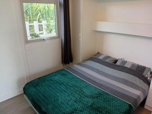 a small bedroom with a bed with a window at Bungalow & Jacuzzi 24h24 7j7 in Petite Île