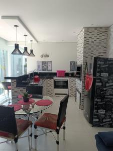 a kitchen with a table with chairs and a refrigerator at Edícula 55m2, aceita pequenos pets in Foz do Iguaçu