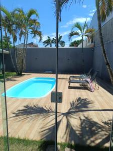 a swimming pool in a backyard with palm trees at Edícula 55m2, aceita pequenos pets in Foz do Iguaçu