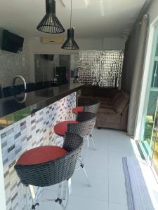 a kitchen with chairs and a bar with a couch at Edícula 55m2, aceita pequenos pets in Foz do Iguaçu
