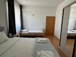 a bedroom with a bed and two beds in it at Apartman Mandurić in Posušje +6 photos