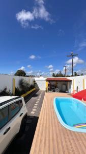 a car parked next to a house with a swimming pool at Casa Lagoa & Praia in Estância
