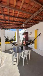 a patio with a table and chairs and a hammock at Casa Lagoa & Praia in Estância