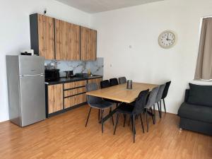 a kitchen with a table and chairs and a refrigerator at Apartman Mandurić in Posušje