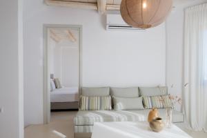a white living room with a couch and a table at White Cliff Villas Paros in Ambelas