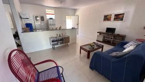 a living room with a blue couch and a table at Casa Lagoa & Praia in Estância