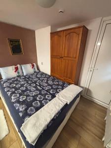 a bedroom with a bed and a wooden cabinet at dato in Arbanasi