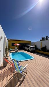 a deck with two chairs and a swimming pool at Casa Lagoa & Praia in Estância