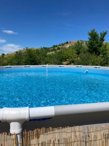 a large swimming pool with blue water at Agriturismo Glamping Pettirosso in Fratta Terme