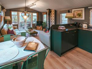 a kitchen with green cabinets and a living room at The Shepherd - Uk50613 in Sabden