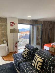 a living room with a couch and a bed at Casa da Zéfinha - STUDIO in Cinfães