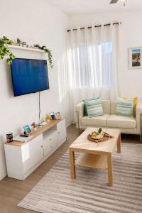 a living room with a couch and a tv at Estrella de Mar in Pedernales