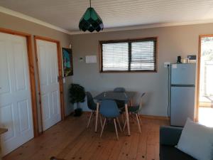 a living room with a table and a refrigerator at The Lekker Plek - Private country cottage in Zuurbraak