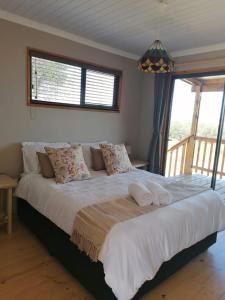 a bedroom with a large bed with towels on it at The Lekker Plek - Private country cottage in Zuurbraak