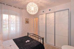 a bedroom with a bed and a chandelier at Villa Radovani Jelsa Hvar in Jelsa +58 photos