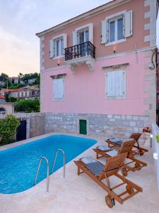 a villa with a swimming pool in front of a house at Villa Radovani Jelsa Hvar in Jelsa