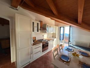 a kitchen with white cabinets and a table with chairs at Casa Marcone in Deiva Marina