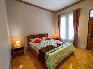a bedroom with a bed and two lamps and a window at Famoris Cottages in Tetebatu