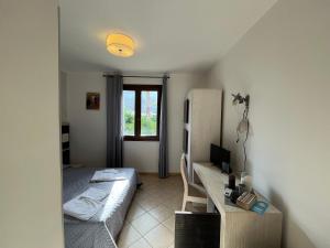 a bedroom with a bed and a desk with a computer at B&B Agrodolce in San Vito lo Capo
