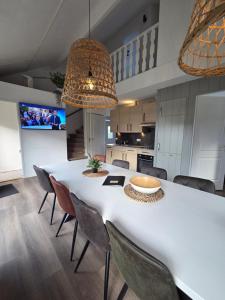a kitchen with a large white table and chairs at Jacuzzi & Sauna Villa 2 in Tzummarum