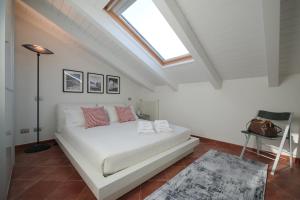 a bedroom with a white bed with a skylight at Casa Marcone in Deiva Marina
