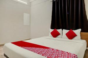 a bedroom with a large bed with red pillows at Hotel O Sai Avenue in Pune +33 photos