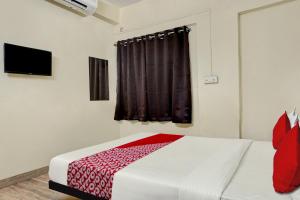 a bedroom with a bed with a red blanket at Hotel O Sai Avenue in Pune