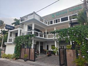 a white building with a balcony on a street at Nature Lanka Guest House in Negombo