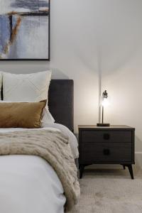 a bedroom with a bed and a table with a lamp at The Brick & Beam Boutique Hotel in Collingwood +69 photos