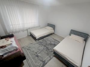 a small room with two beds and a couch at Apartman Alić in Vogošća